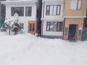 a house with a pile of snow in front of it at New Heaven Rose in Pahalgām