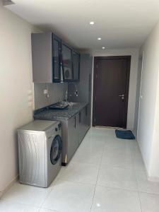 a kitchen with a washing machine and a sink at Modern Rooftop with Stunning View Iconic Tower in Madīnat aţ Ţalāʼi‘