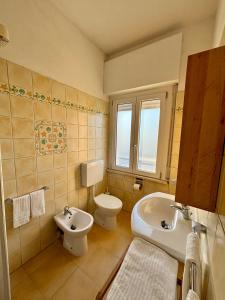 a bathroom with a white toilet and a sink at Hotel Gianlore in Milano Marittima +47 photos
