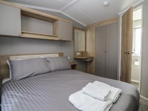 a bedroom with a bed with white towels on it at The Swift in St Bees