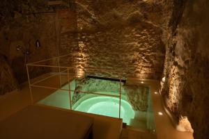eine Badewanne in einer Höhle mit einer Steinwand in der Unterkunft Mileca Sciù Sciù - Camere, Suite Zona Benessere in Sciacca