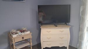 a television on top of a dresser with a dresser at La benvingude CH d'hôte in Nyons +4 photos