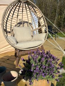 a swing chair and a vase of purple flowers at Fyn Glamping in Nyborg