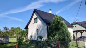 a white house with a black roof at Dům in Hrabowa