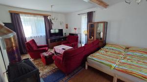 a bedroom with a bed and two red chairs at Dům in Hrabowa