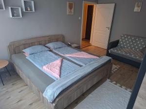 a bedroom with a bed and a chair in it at Dombó apartman in Dombóvár