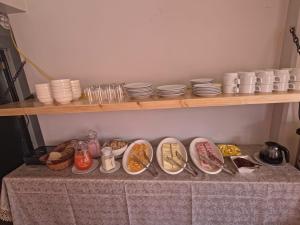 a table topped with plates and bowls of food at Hatun Wasi Puno in Puno