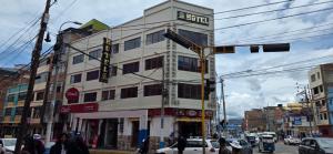a building with a sign on it on a city street at Hatun Wasi Puno in Puno
