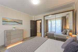 a bedroom with a bed and a large mirror at Infinity View 3 Shkorpilovci in Shkorpilovtsi