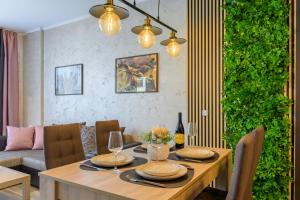 a dining room with a table and a green wall at Infinity View 3 Shkorpilovci in Shkorpilovtsi