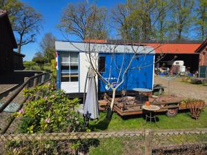a blue and white tiny house in a yard at Tinyhaus, Bauwagen, Noltenius in Bülstedt
