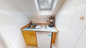 a small kitchen with a sink and a counter top at Landhaus Gerdts - 1 in Cuxhaven