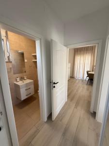 a bathroom with a sink and a white door at Apartments by Resort Čulina in Metajna +131 photos