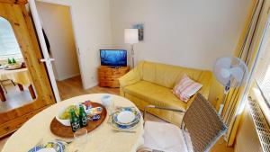 a living room with a yellow couch and a table at Landhaus Gerdts - 1 in Cuxhaven