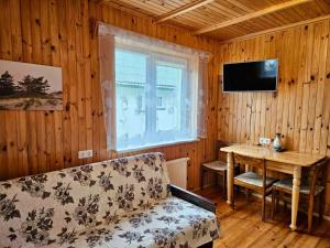 a living room with a couch and a table and a television at Pas Aldoną in Šventoji