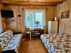 a bedroom with two beds and a table and a refrigerator at Pas Aldoną in Šventoji