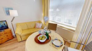 a living room with a table and a couch at Landhaus Gerdts - 1 in Cuxhaven