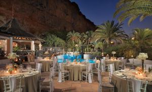 a wedding reception with white tables and chairs at Hotel Jardín Tecina in Playa de Santiago