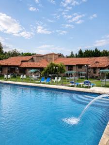 a pool with a fountain in front of a resort at Villa de Merlo All Inclusive & Spa by MH in Merlo
