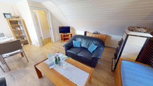 a living room with a leather chair and a table at Landhaus Gerdts - 4 in Cuxhaven +15 photos