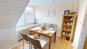 a dining room with a table and chairs and a window at Landhaus Gerdts - 4 in Cuxhaven