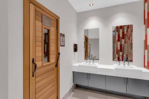 a bathroom with two sinks and a wooden door at Executive Condo with Parking DT Ottawa in Ottawa +24 photos