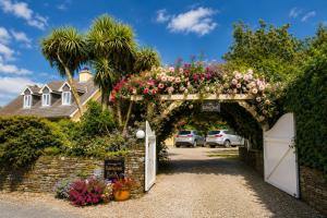 ein mit Blumen geschmückter Torbogen vor einem Haus in der Unterkunft Edencrest B&B in Bantry