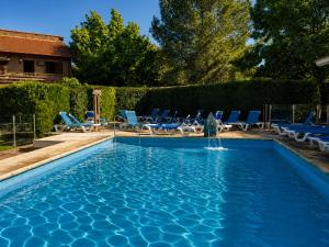 a swimming pool with chairs and a fountain at Villa de Merlo All Inclusive & Spa by MH in Merlo