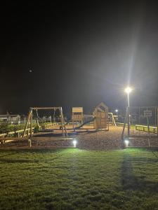 an empty playground at night with a street light at Sheppey Village Roxy in Leysdown-on-Sea +7 photos