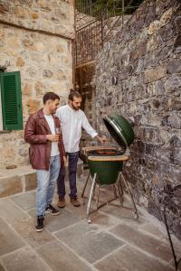 two men standing in front of a grill at Villa Eremo Cinque Terre in Castiglione Chiavarese