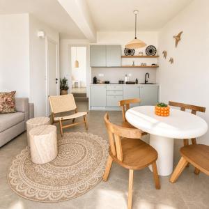 a kitchen and a living room with a table and chairs at Halo Tinos - PHOEBUS in Tinos