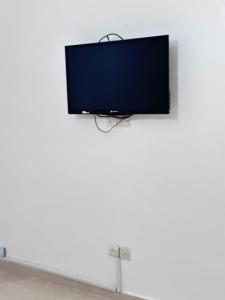 a flat screen tv hanging on a white wall at Rmilate Coast Apartment in Asilah