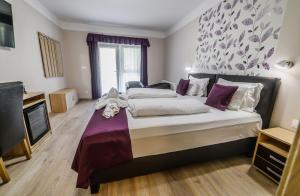 a bedroom with a large bed and a tv at Az Idill in Cserszegtomaj