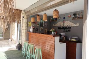 a bar with green stools in a restaurant at My Angels Alaçatı in Alaçatı