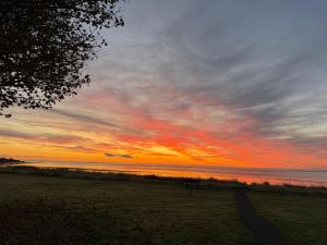 a sunset on a beach with the ocean at Firthview Golspie in Golspie +2 photos