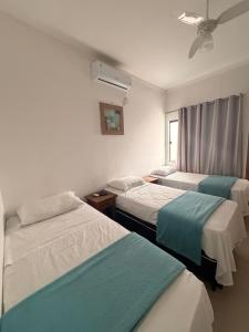 a hospital room with three beds and a window at Pouso Mineiro in São João Batista do Glória