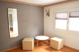 a room with a table and two stools and a mirror at Ufer Nest in Buochs in Buochs