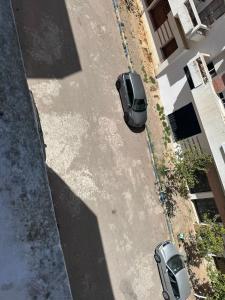 an overhead view of two cars parked on a street at Rmilate Coast Apartment in Asilah