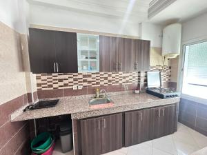 a kitchen with a sink and a counter top at Rmilate Coast Apartment in Asilah