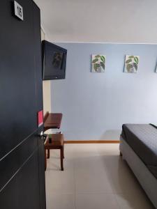a bedroom with a bed and a tv on the wall at Hostelfc Marly in Bogotá