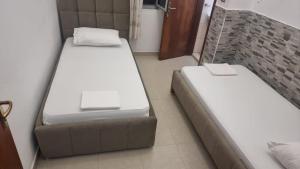 two beds in a small room with at Guest House Kocollari in Gjirokastër