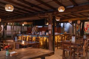 a restaurant with wooden tables and chairs and lights at Nílu Puerto Escondido by Selina in Puerto Escondido