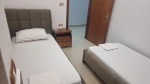 a small room with two beds and a mirror at Guest House Kocollari in Gjirokastër