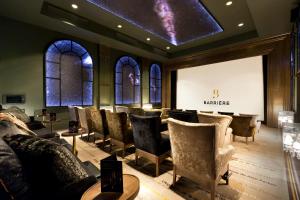 a waiting room with chairs and a projection screen at Hôtel Barrière Le Majestic Cannes in Cannes