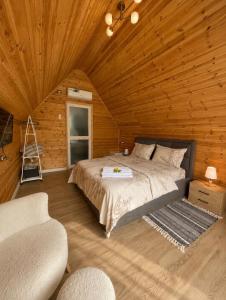 a bedroom with a bed in a wooden cabin at Guest house Panorama in Koman +12 photos