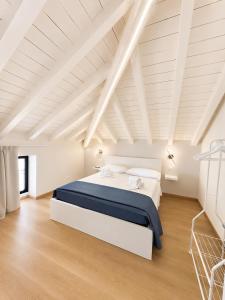ein weißes Schlafzimmer mit einem großen Bett im Dachgeschoss in der Unterkunft Sebì Suite in Iseo