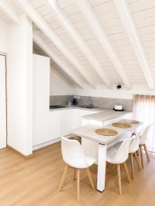 eine weiße Küche mit weißem Tisch und Stühlen in der Unterkunft Sebì Suite in Iseo