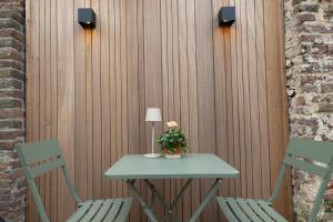 a table with two chairs and a table with a lamp at Maison Dieu in Hasselt