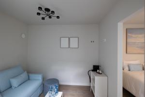 a living room with a blue couch and a bed at Maison Dieu in Hasselt
