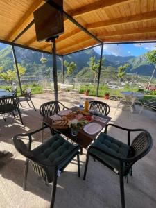 a table and chairs on a patio with a view at Guest house Panorama in Koman